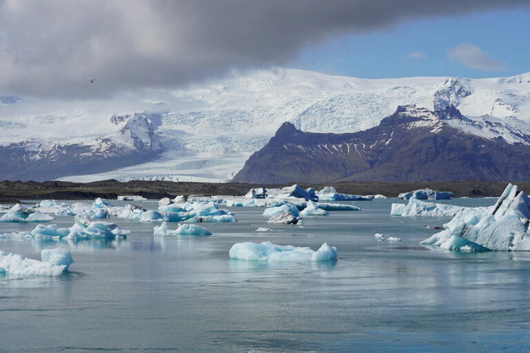 Glacier lagoon in Iceland with drifting ice chunks and snowy mountain backdrop