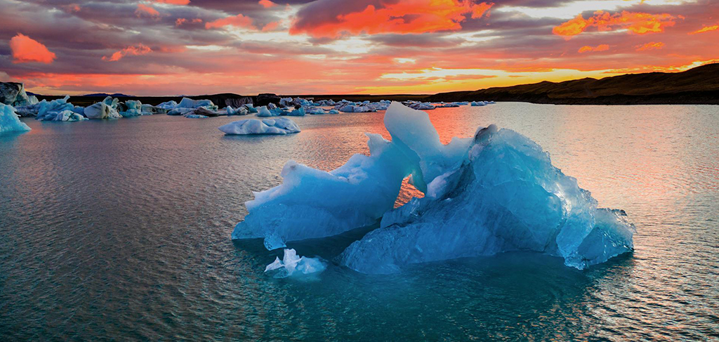 Sunset over glacier lagoon in Iceland with floating ice and dramatic sky