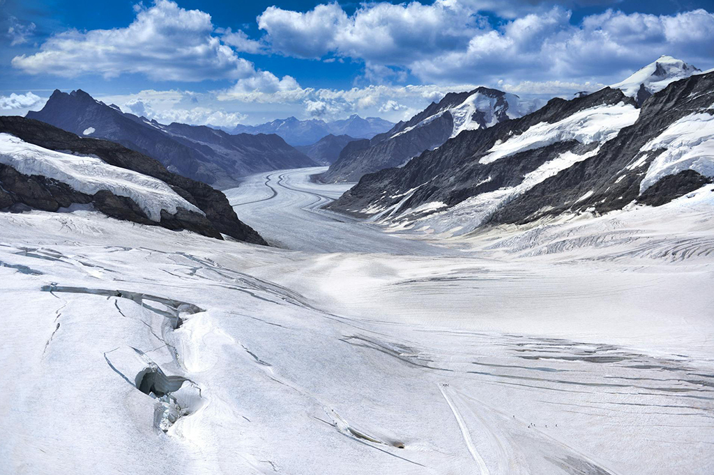 Snow-covered glacier landscape in the Swiss Alps under clear blue sky