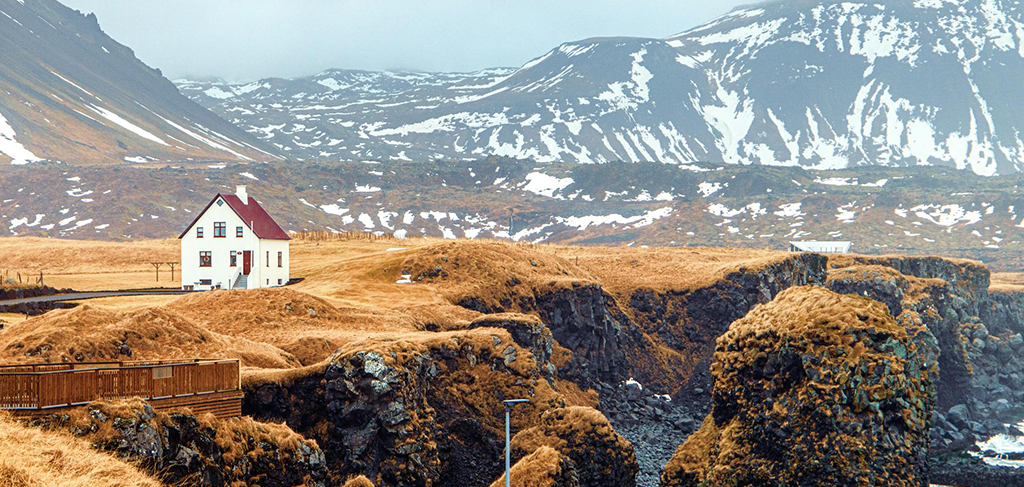 Iceland countryside home near dramatic cliffs and mountain landscape